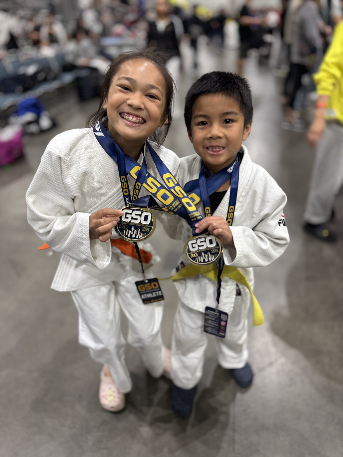 Two young San Diego Judo students holding their tournament medals